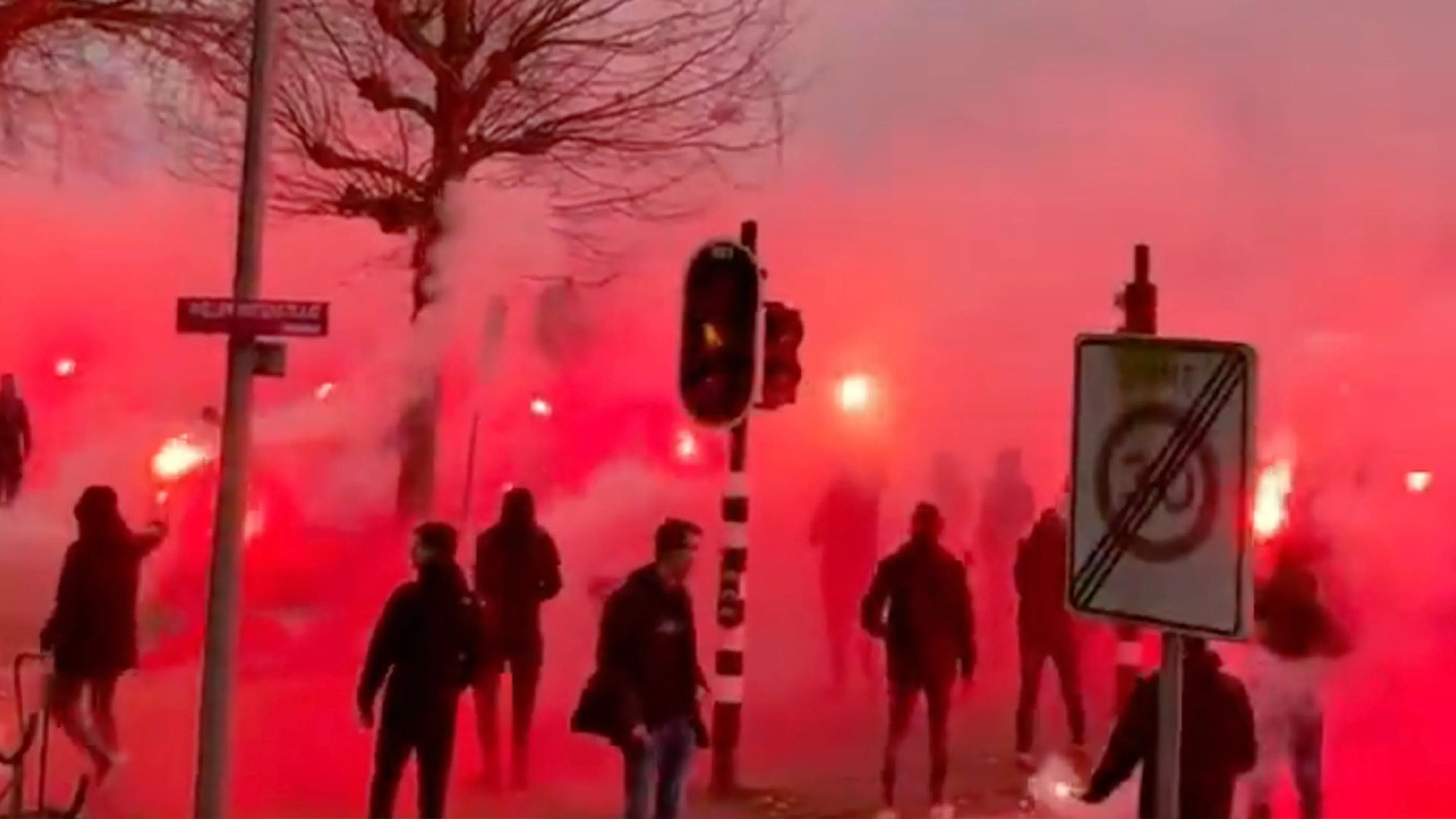 Ajax-fans zwaaien spelersbus uit met fakkelzee in aanloop naar de Klassieker
