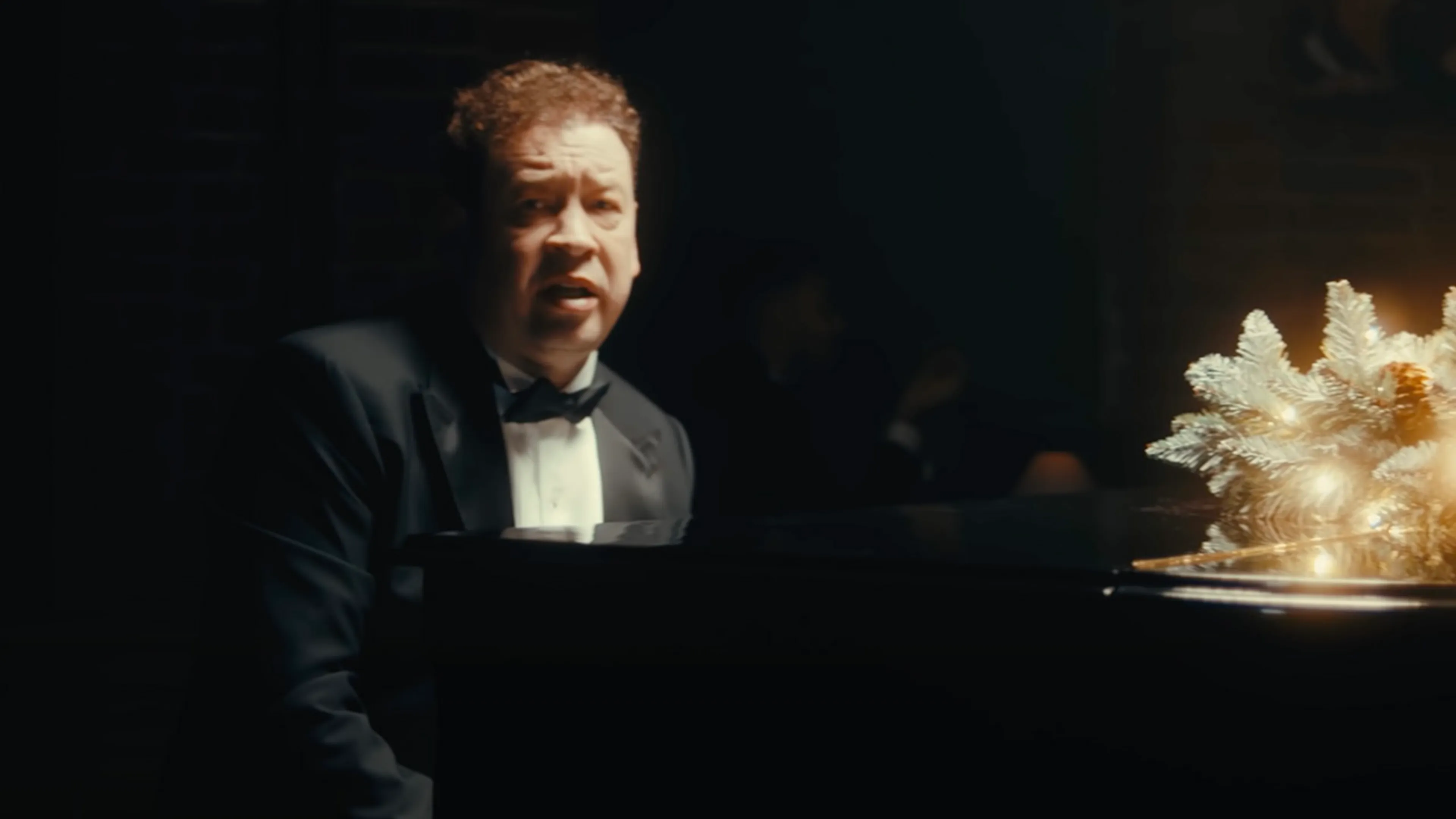 Leonid Slutsky zingend achter piano voor kerstboodschap van Rubin Kazan