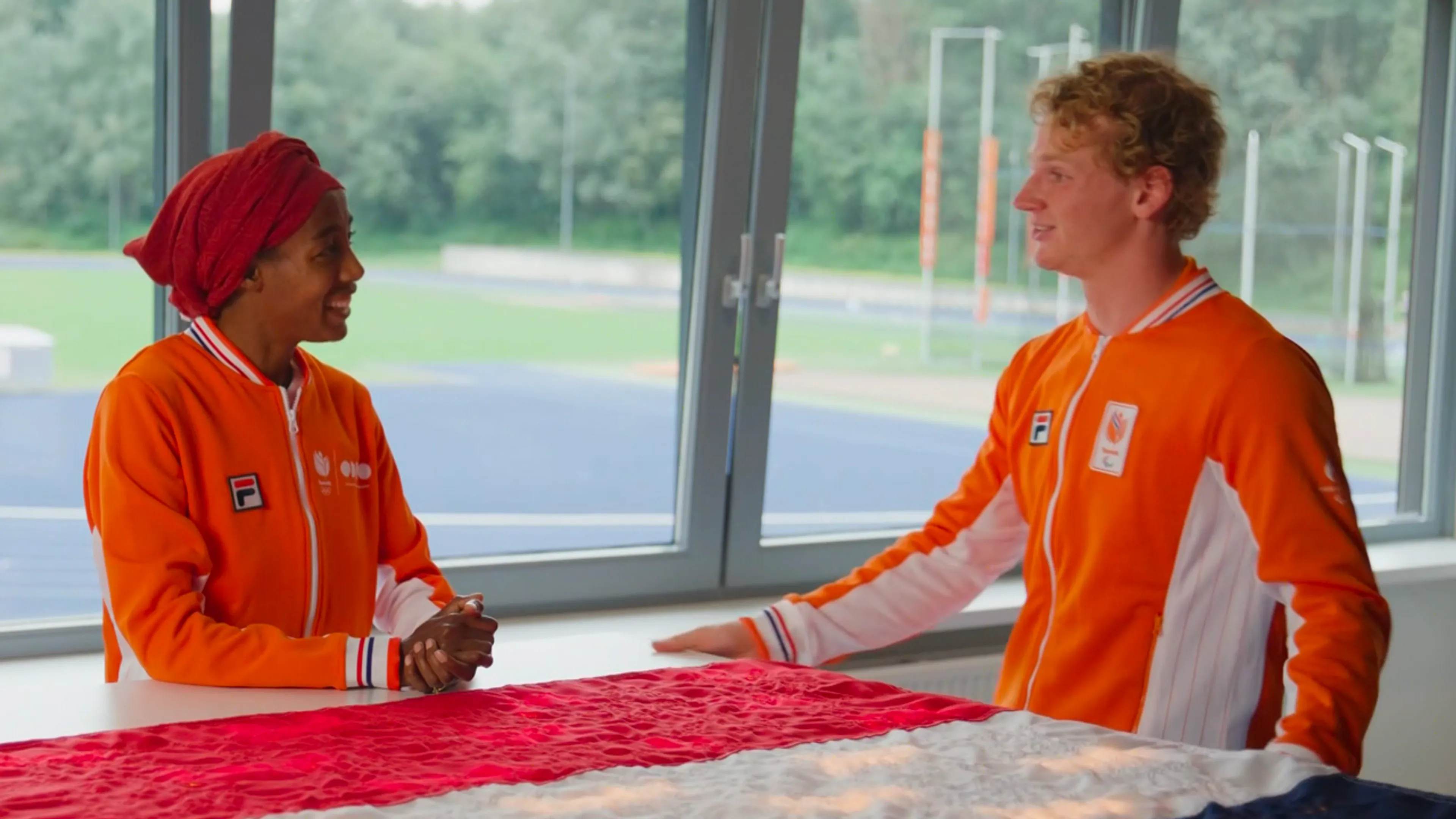 Prachtig! Sifan Hassan draagt Nederlandse vlag over aan Joël de Jong