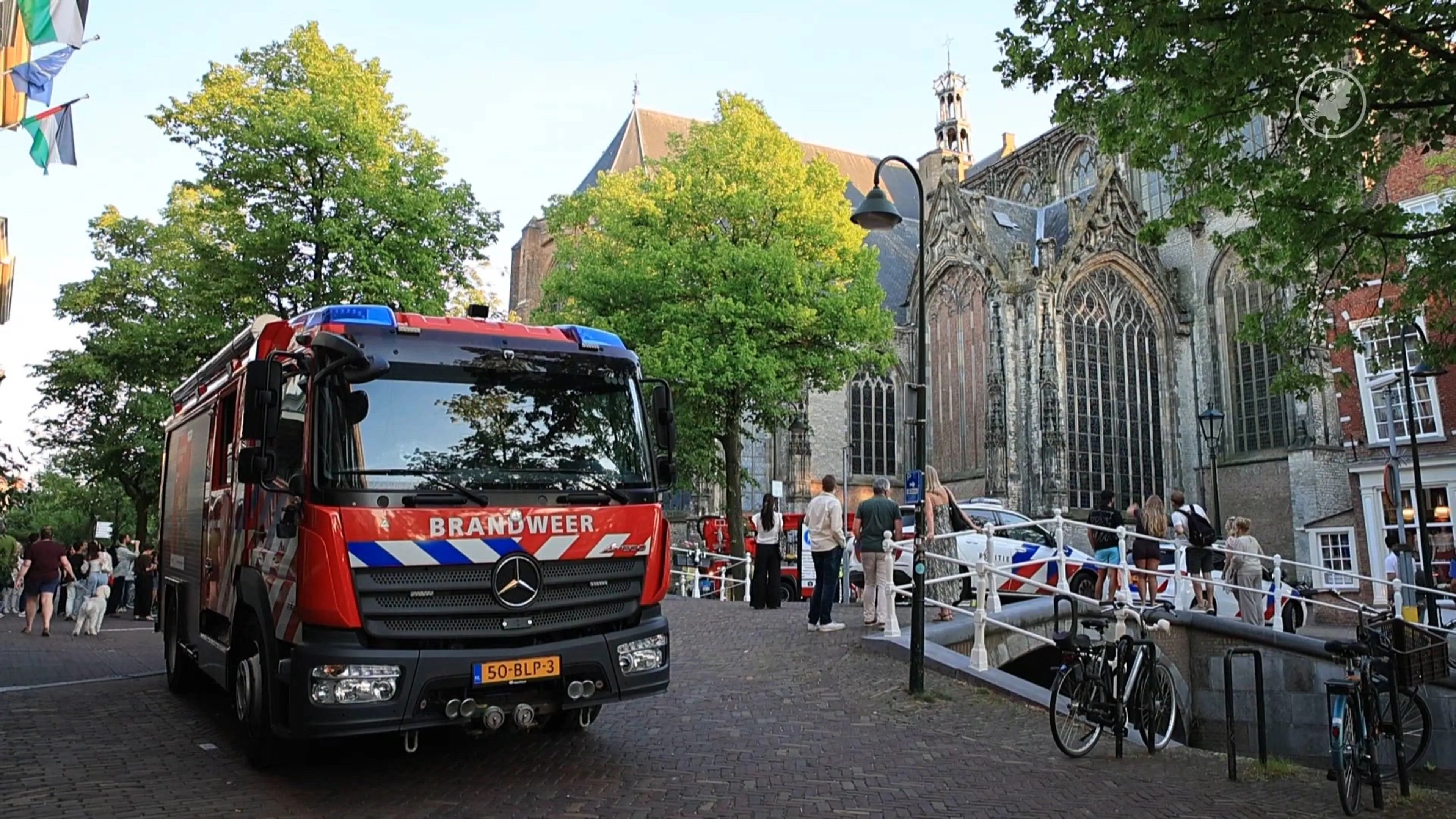 Man klimt dak van Oude Kerk Delft op, hulpdiensten ter plaatse