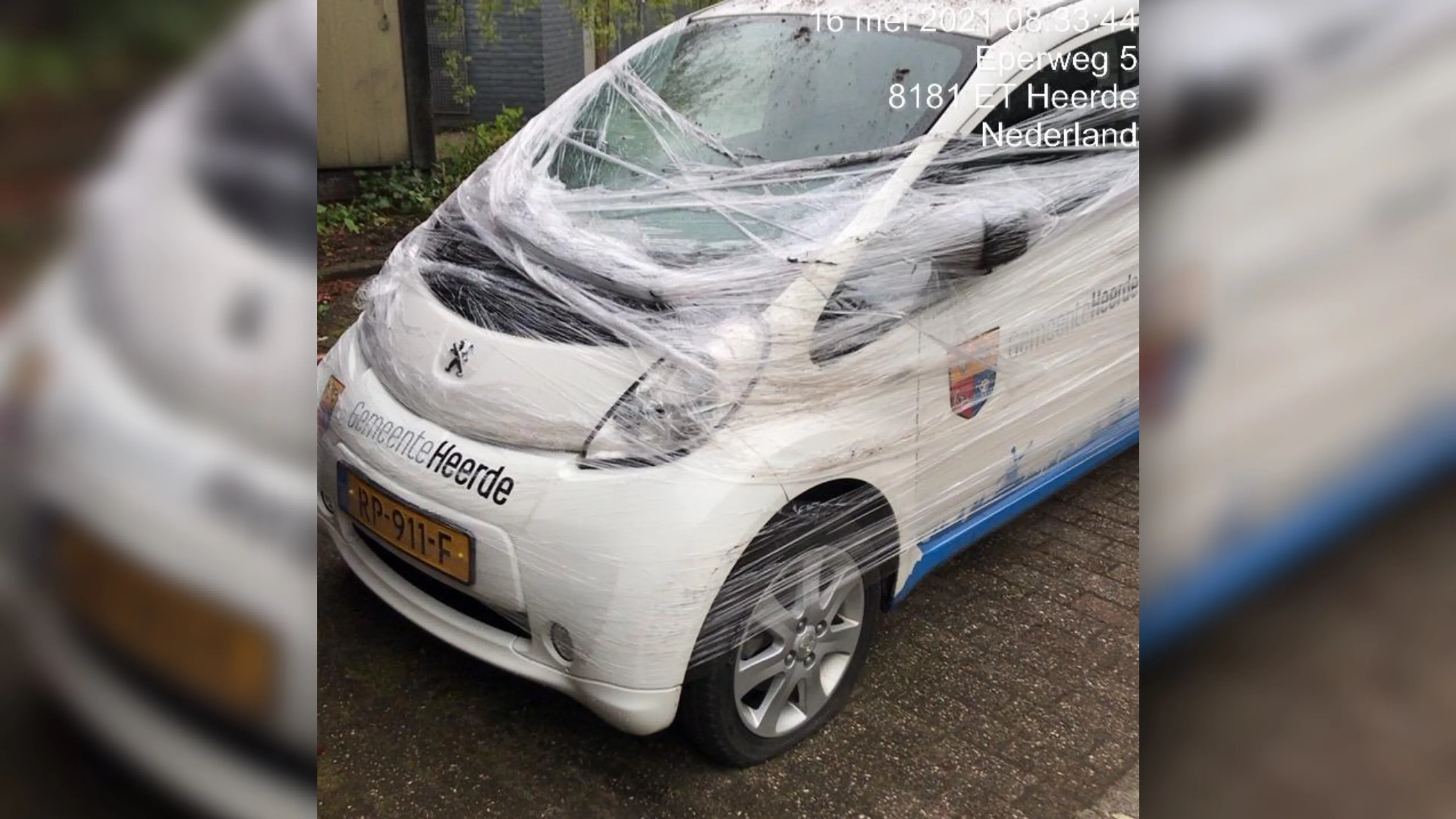 Dienstauto gemeente Heerde omwikkeld in plastic folie, alle banden lek gestoken
