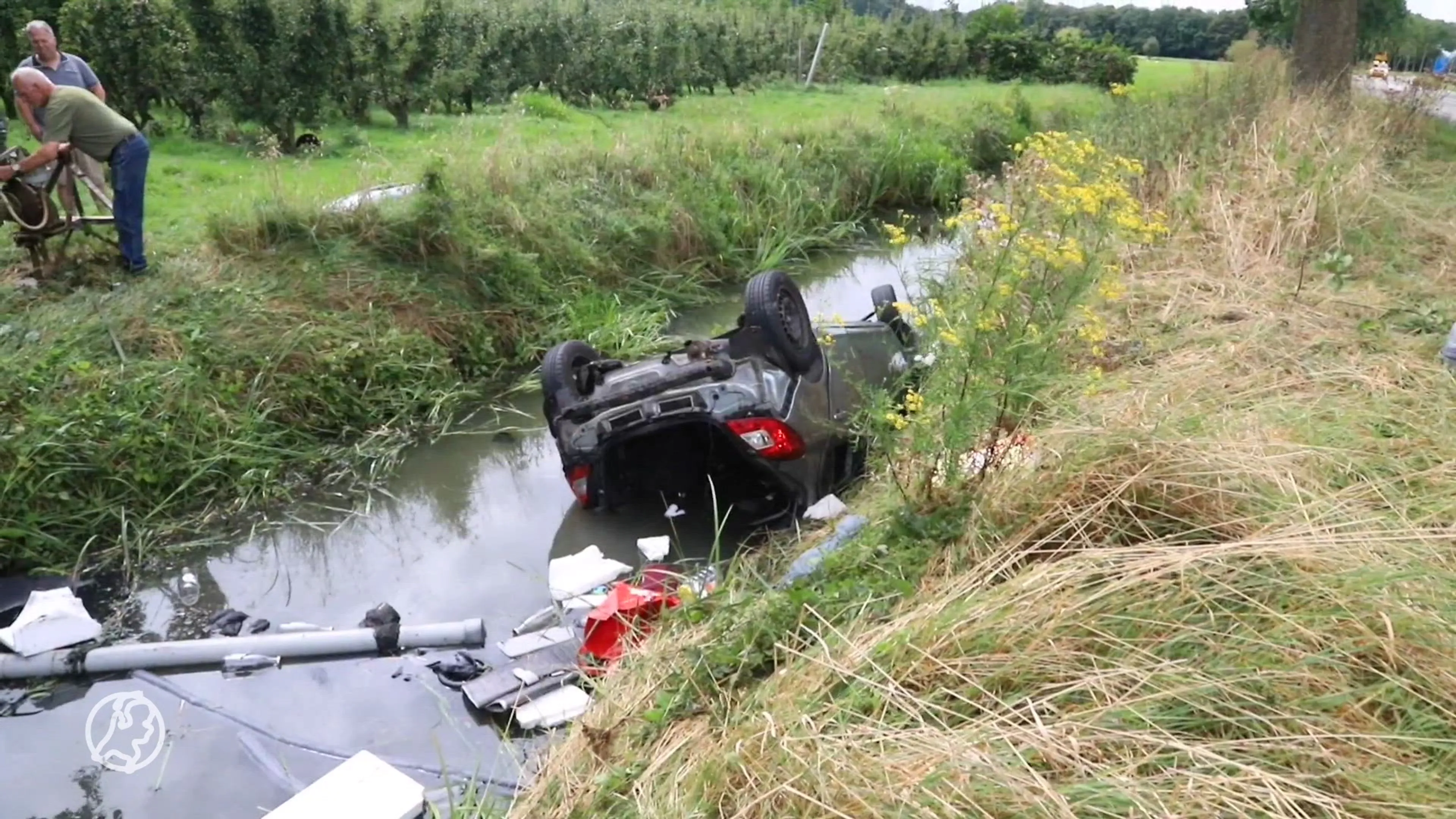 Gezin met baby belandt met auto in de sloot, omstanders schieten te hulp