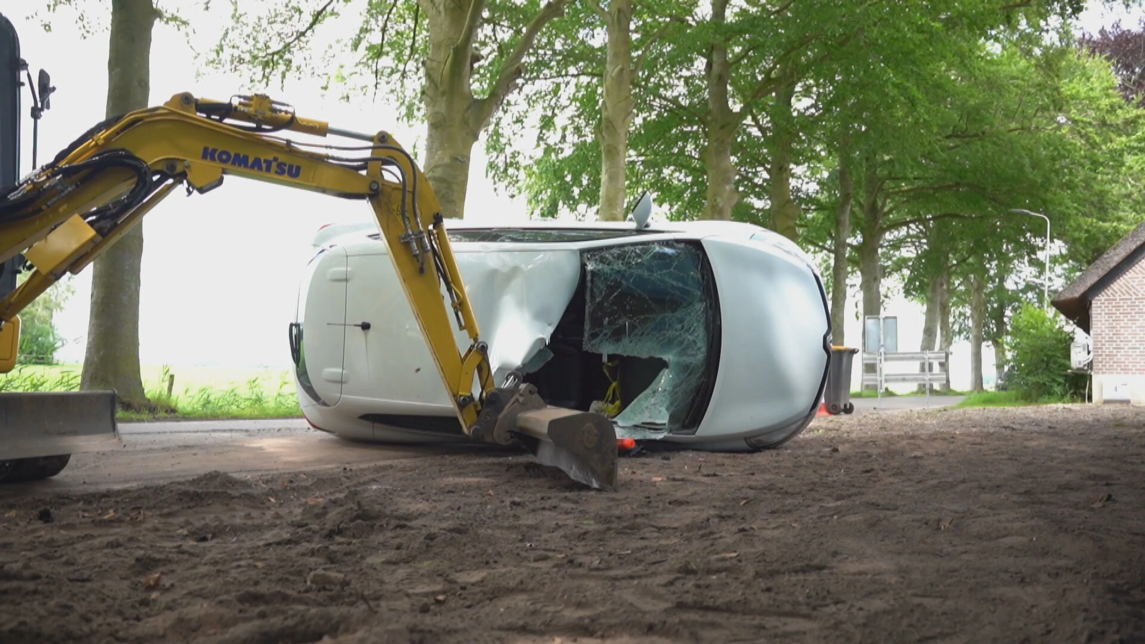 Bizar: Graafmachine sleurt auto mee bij botsing