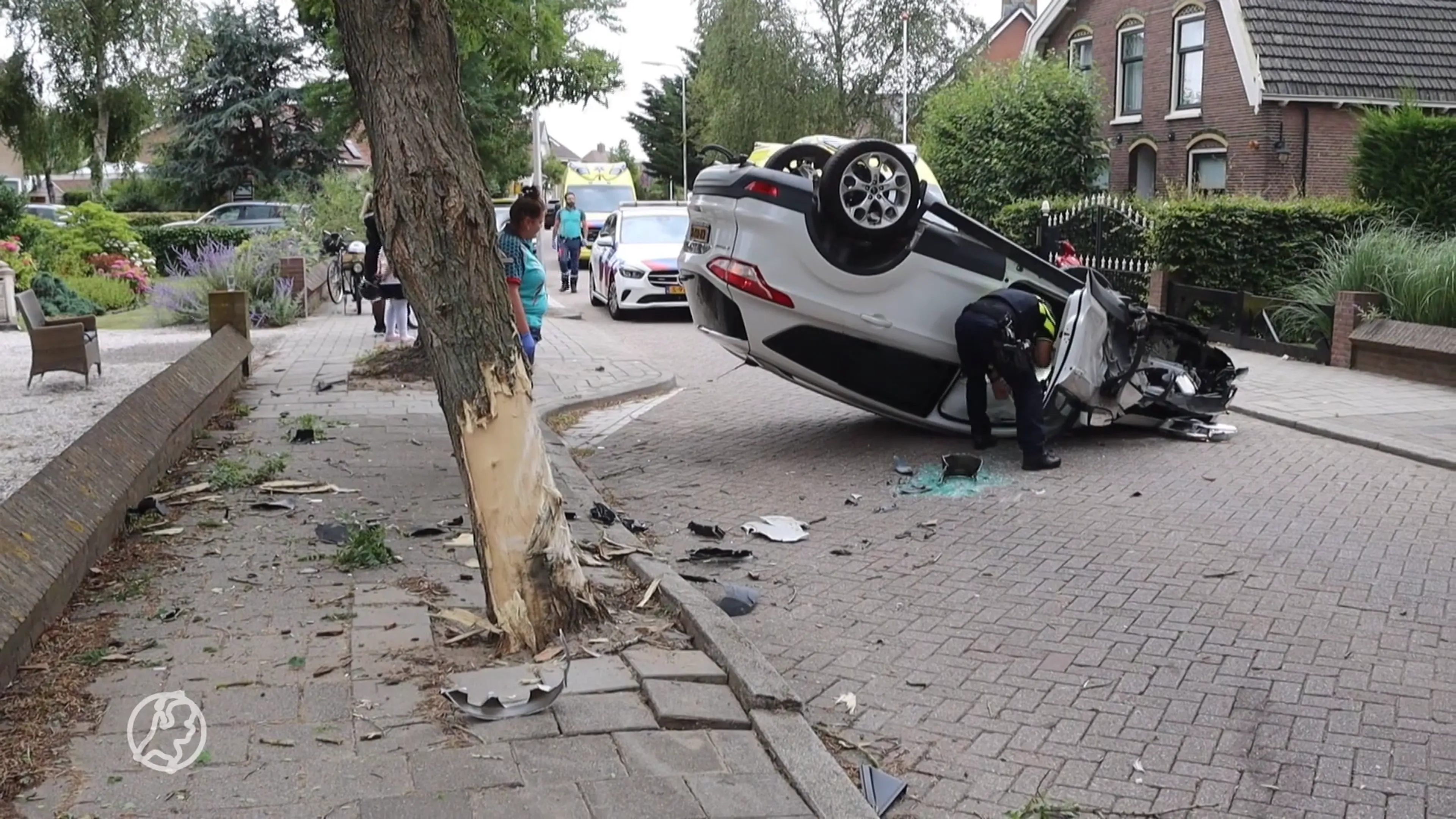 Auto vliegt over de kop na botsing met boom, twee gewonden