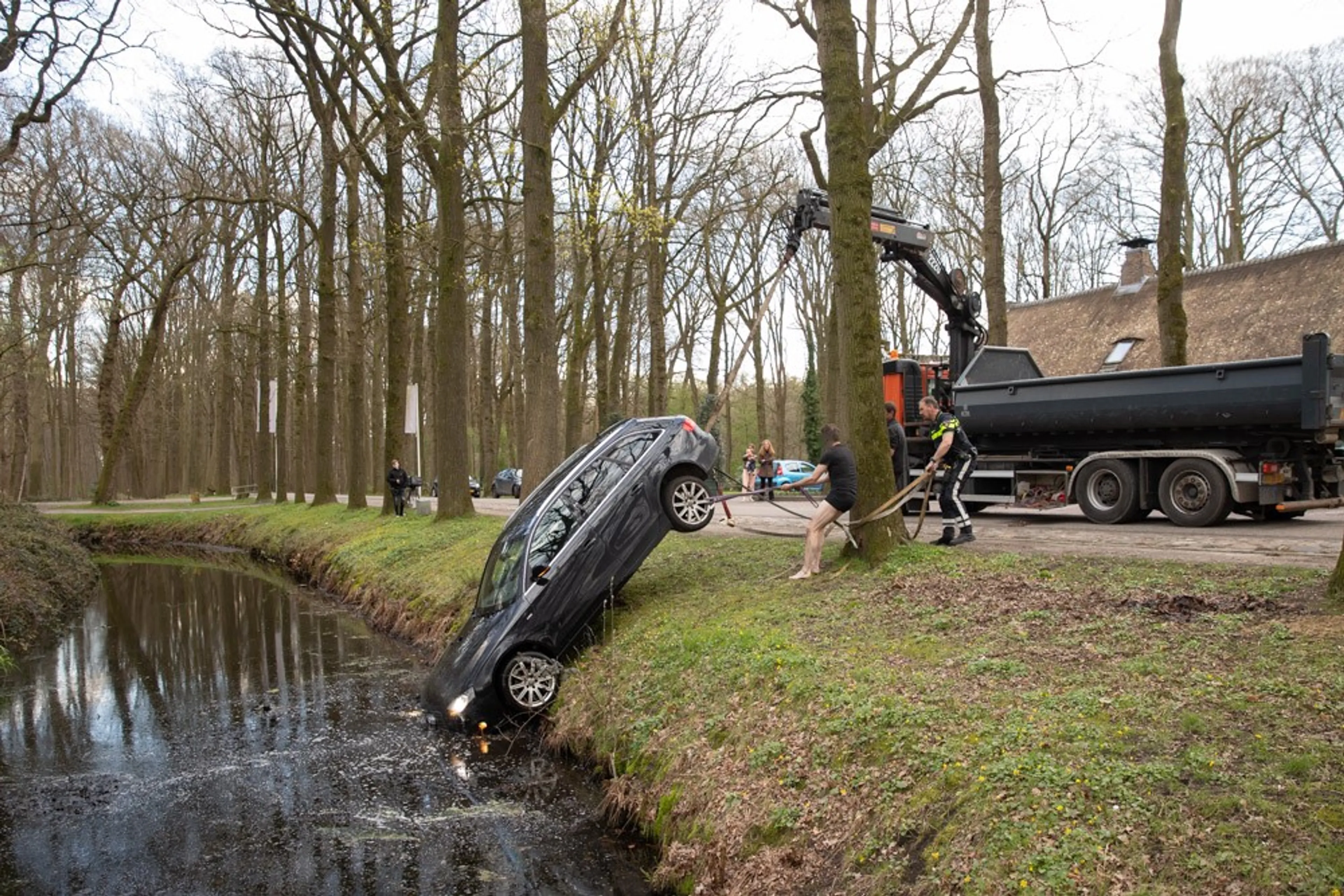 Man vergeet handrem en ziet hoe auto in de gracht rolt