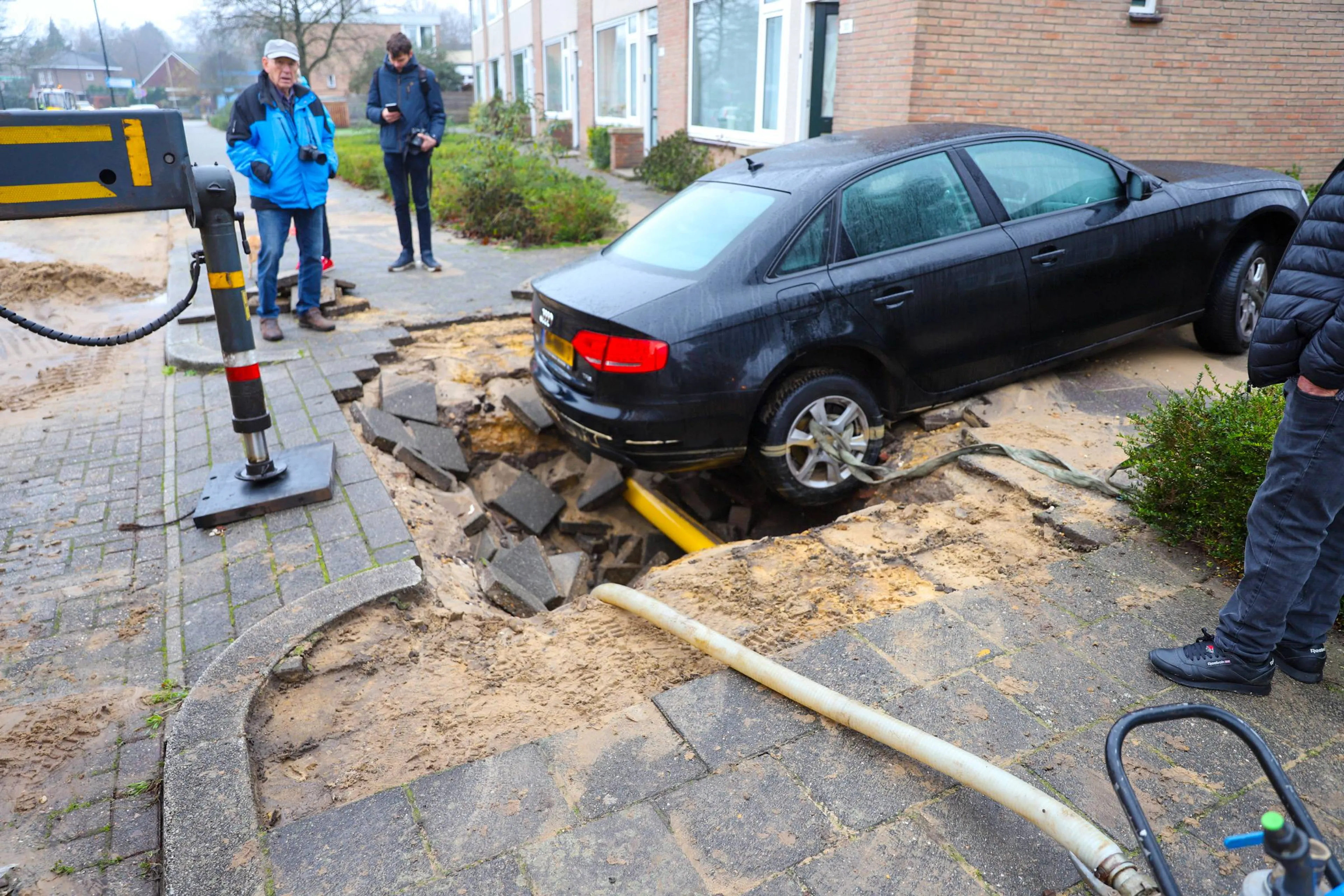 Auto zakt weg in sinkhole na gebroken waterleiding