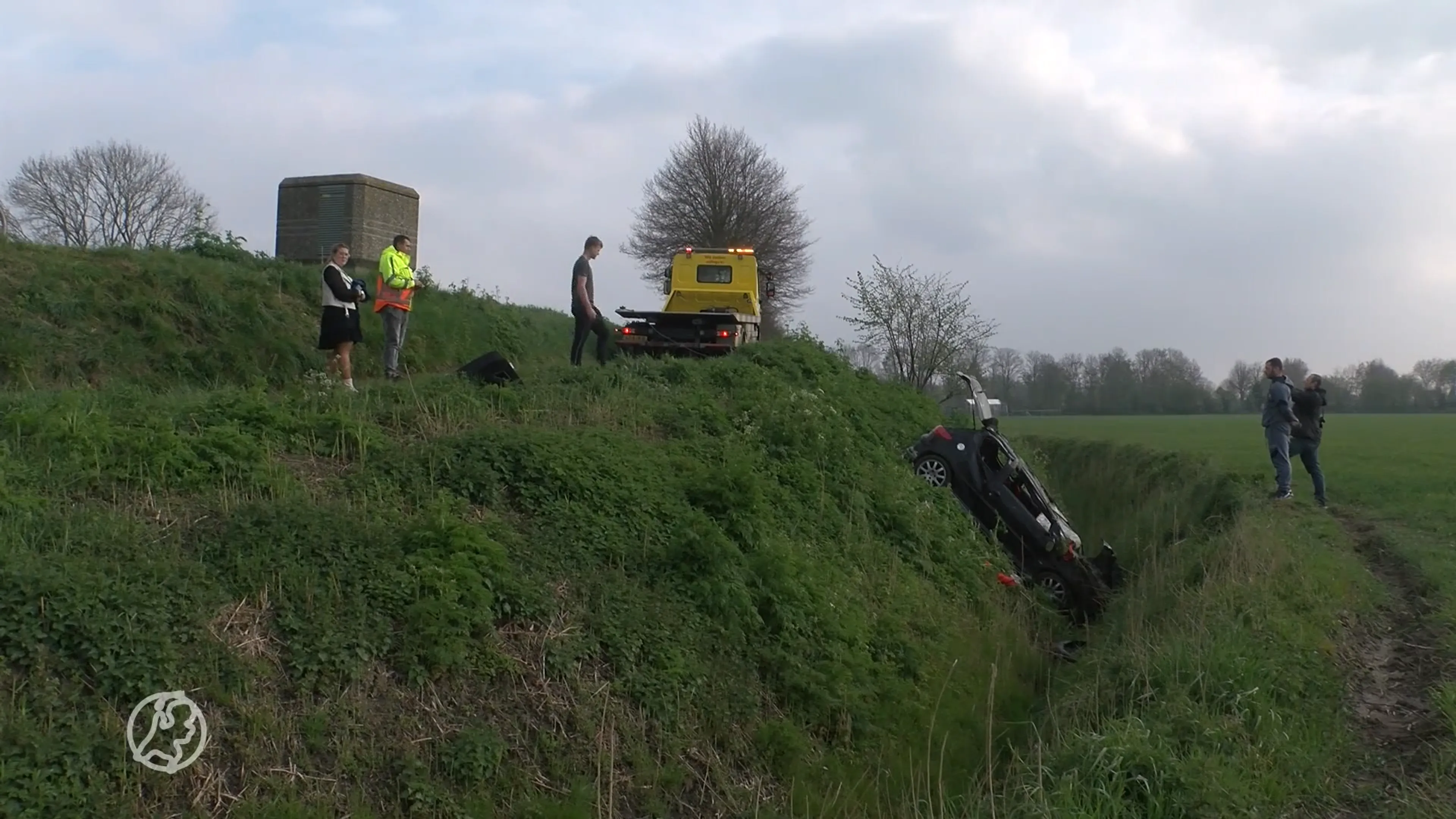 Auto komt op dak in sloot terecht, brandweer moet beklemde inzittende bevrijden