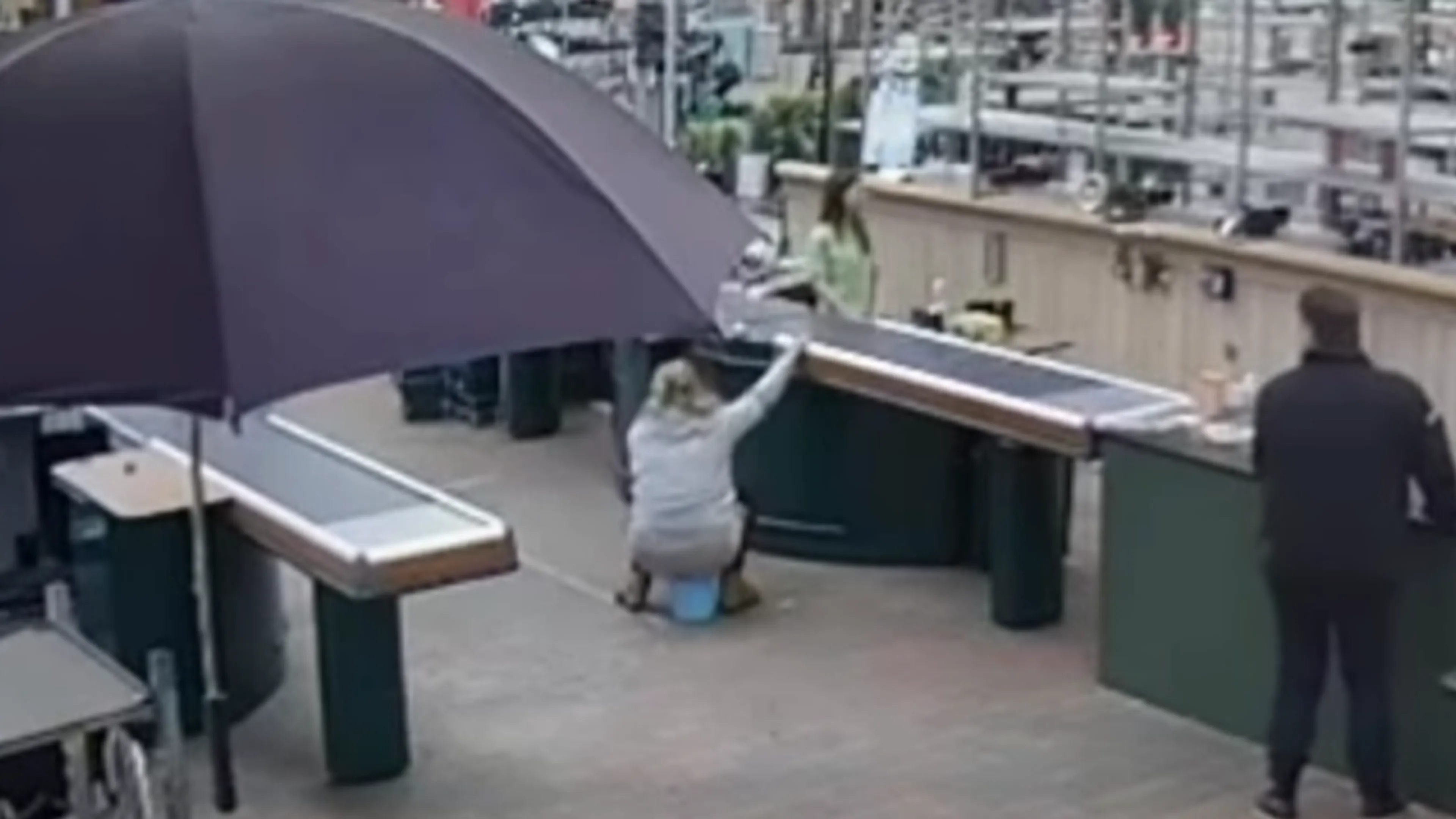 Bizar: vrouw plast in emmer in tuincentrum en gooit 'm leeg onder kassa