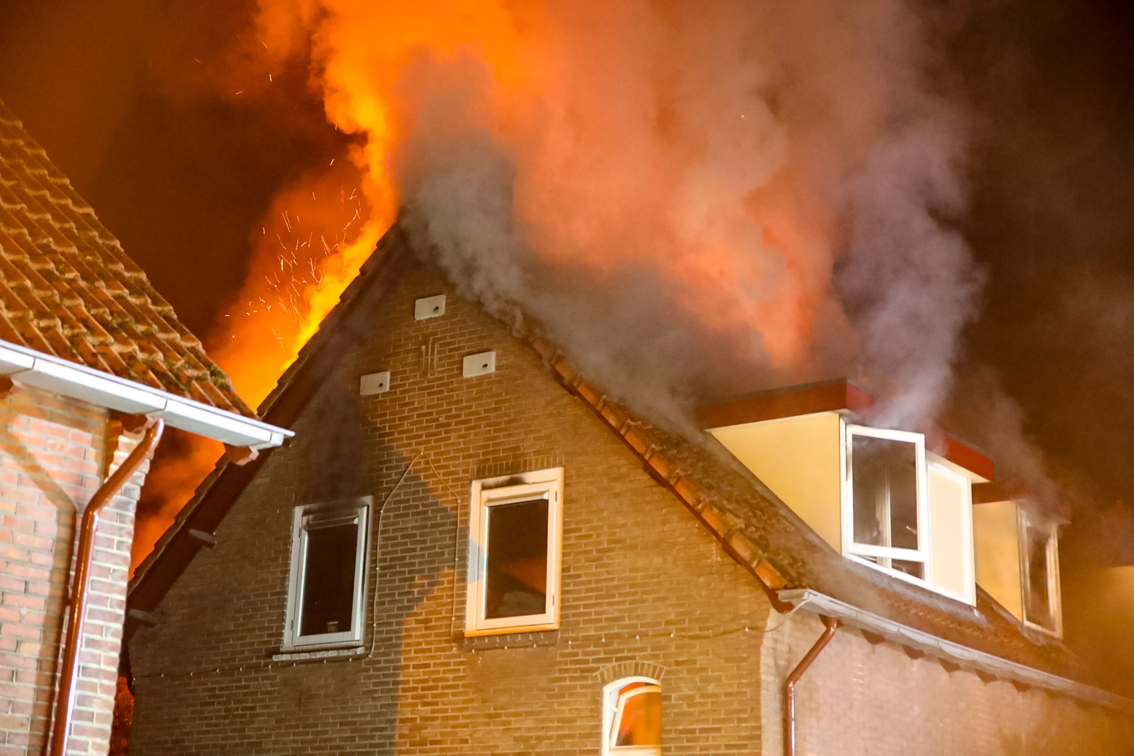 Vlammen slaan uit dak bij brand in rijtjeswoning Apeldoorn, twee mensen gewond