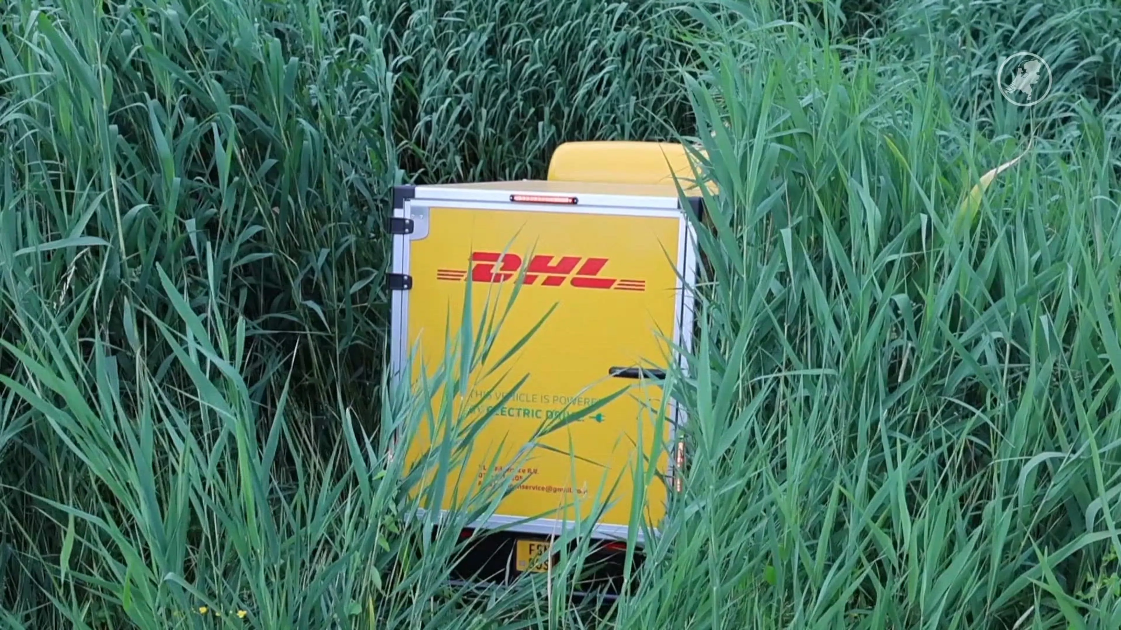 DHL-bezorger laat telefoon vallen: wagentje rolt sloot in