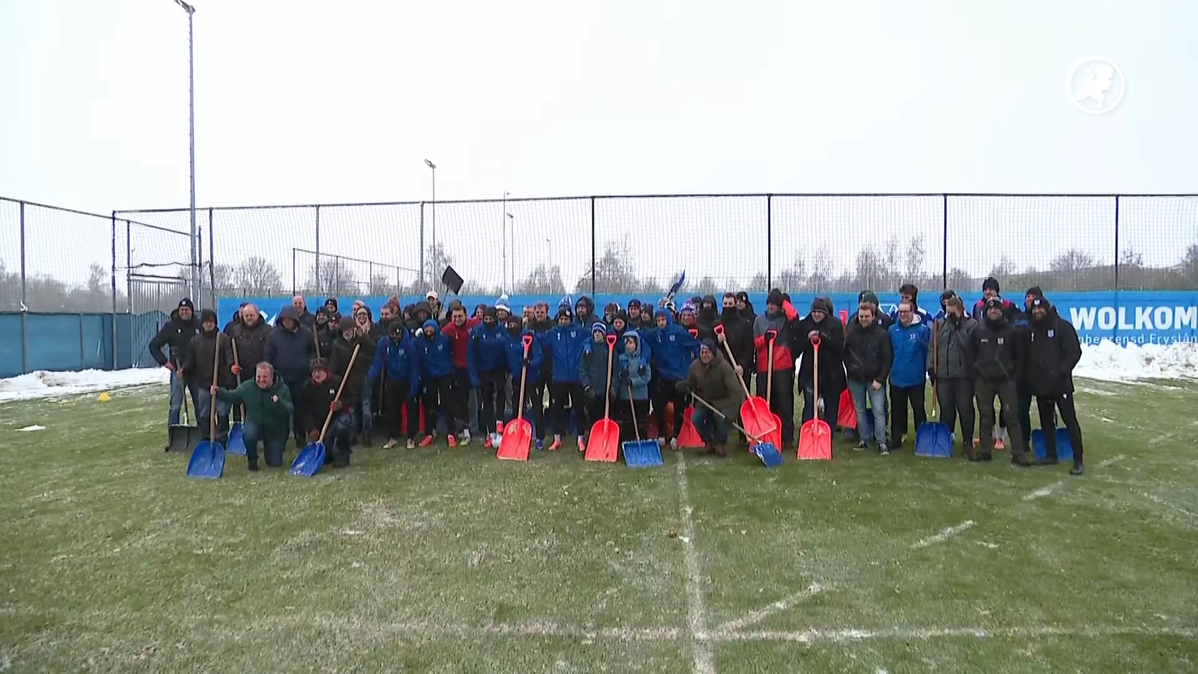 Fans SC Heerenveen met sneeuwschep op pad om veld sneeuwvrij te maken