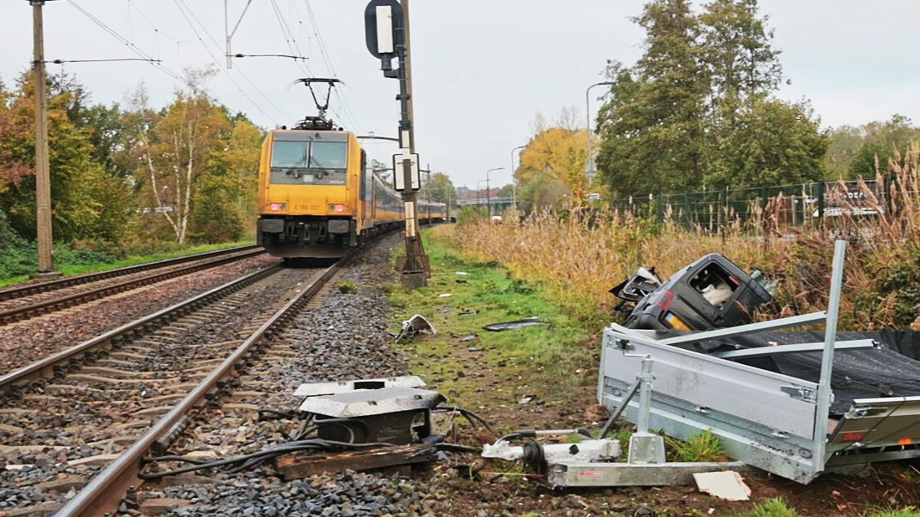 Trein boort zich door vaststaande auto met aanhanger op overweg