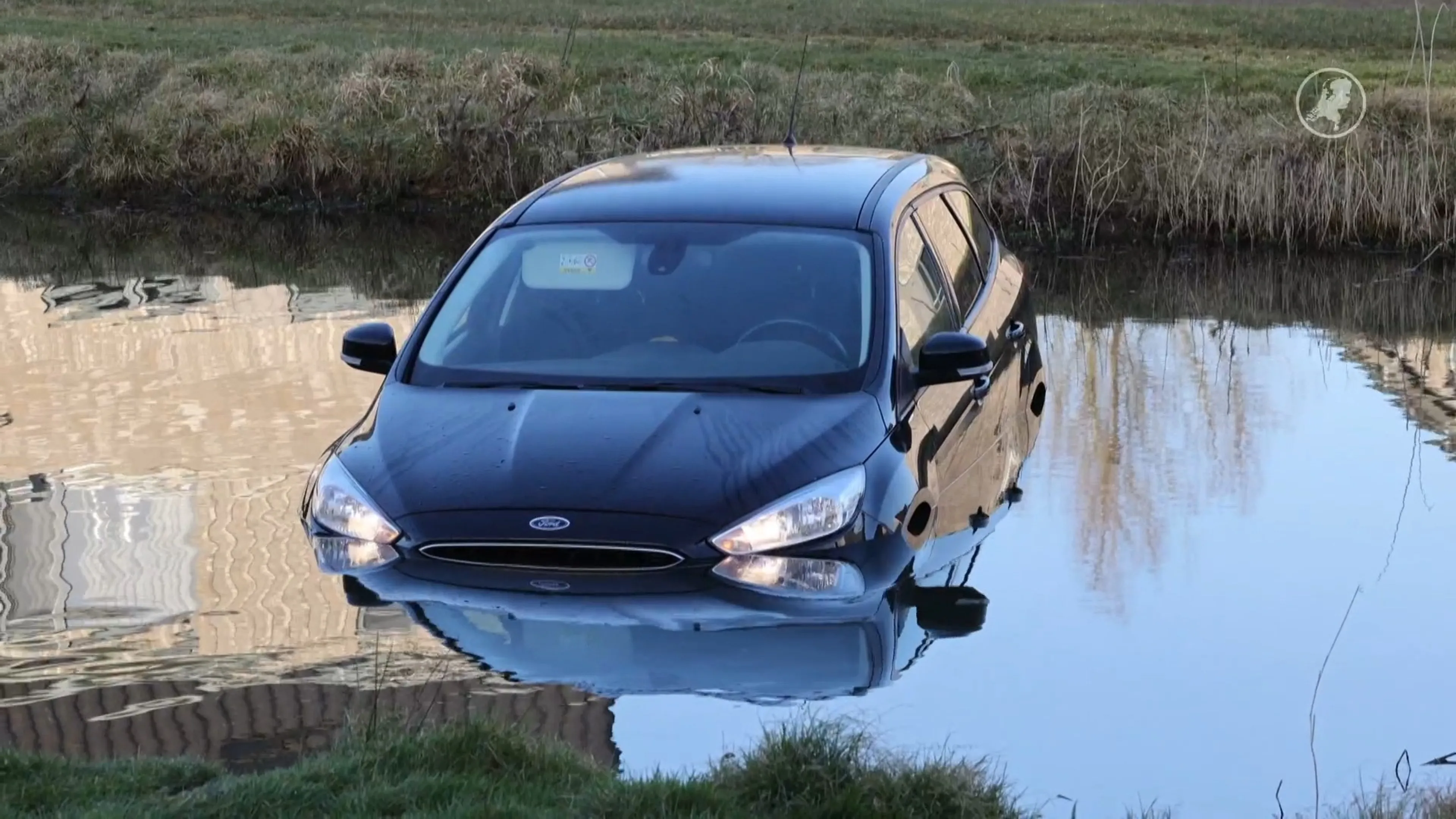 Vader vergeet handrem, auto met twee kinderen rolt het water in