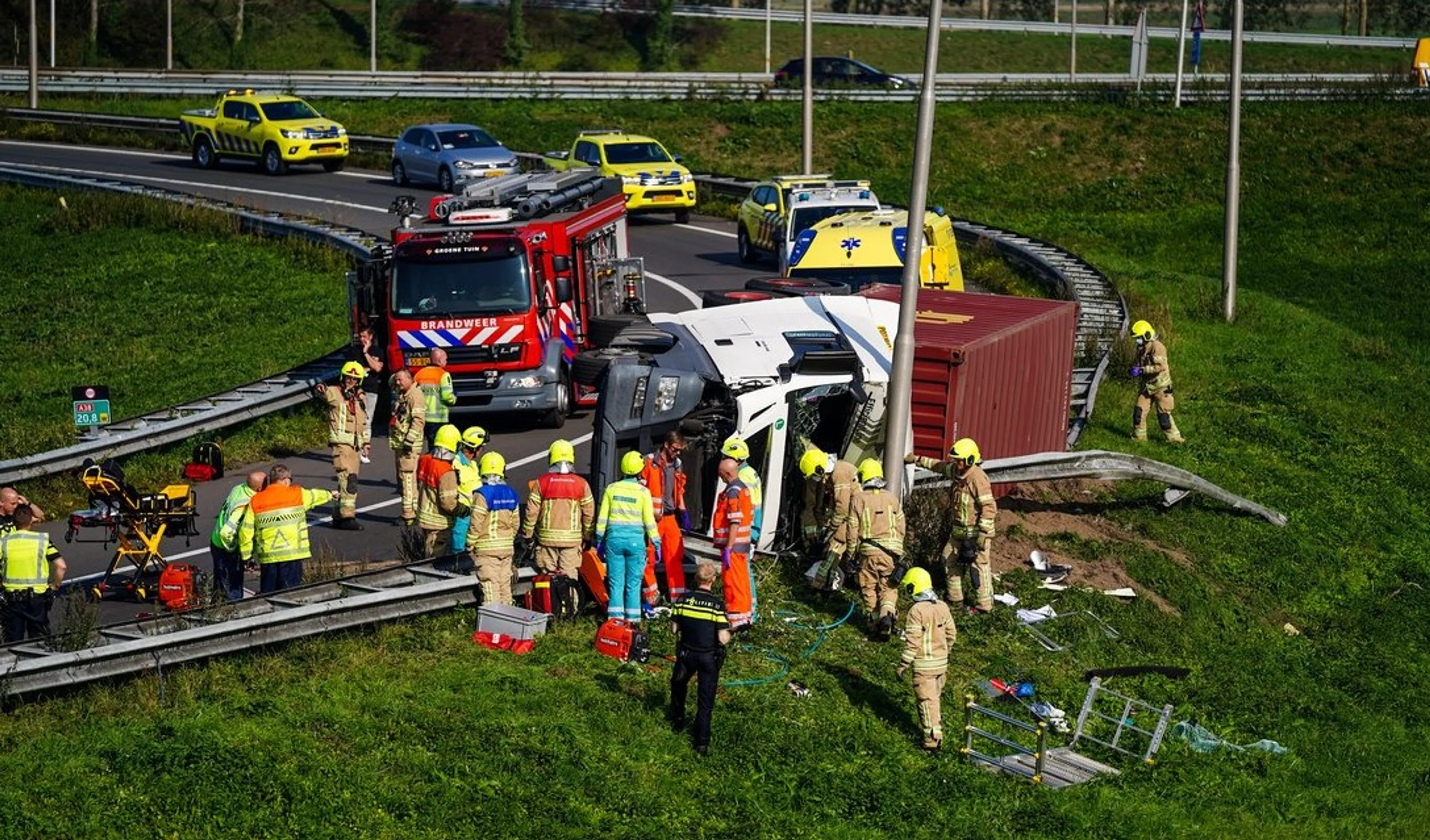 Vrachtwagen kantelt in bocht van A15, chauffeur raakt ernstig bekneld
