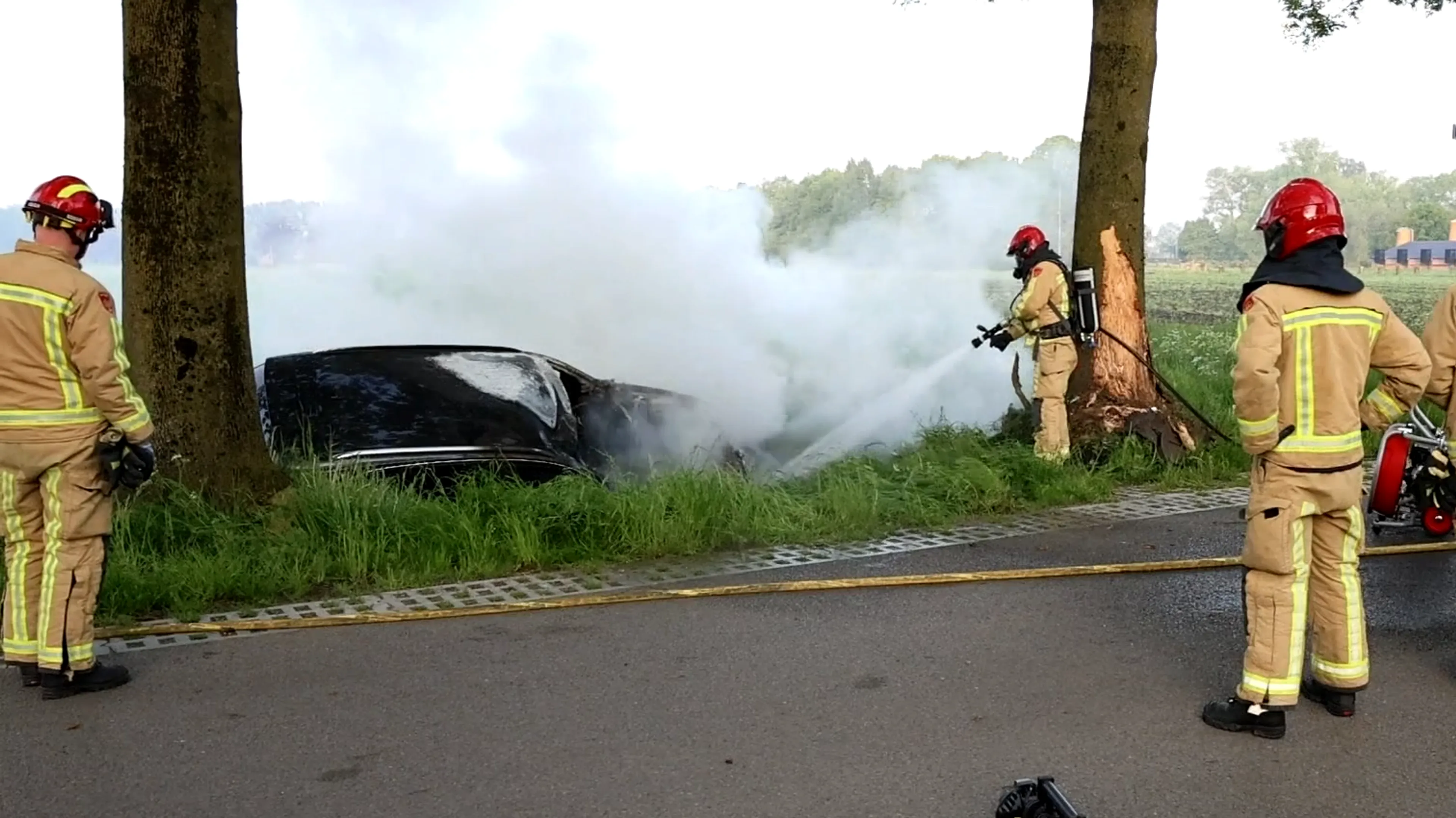 Auto crasht hard tegen boom, stort in sloot en vliegt in brand