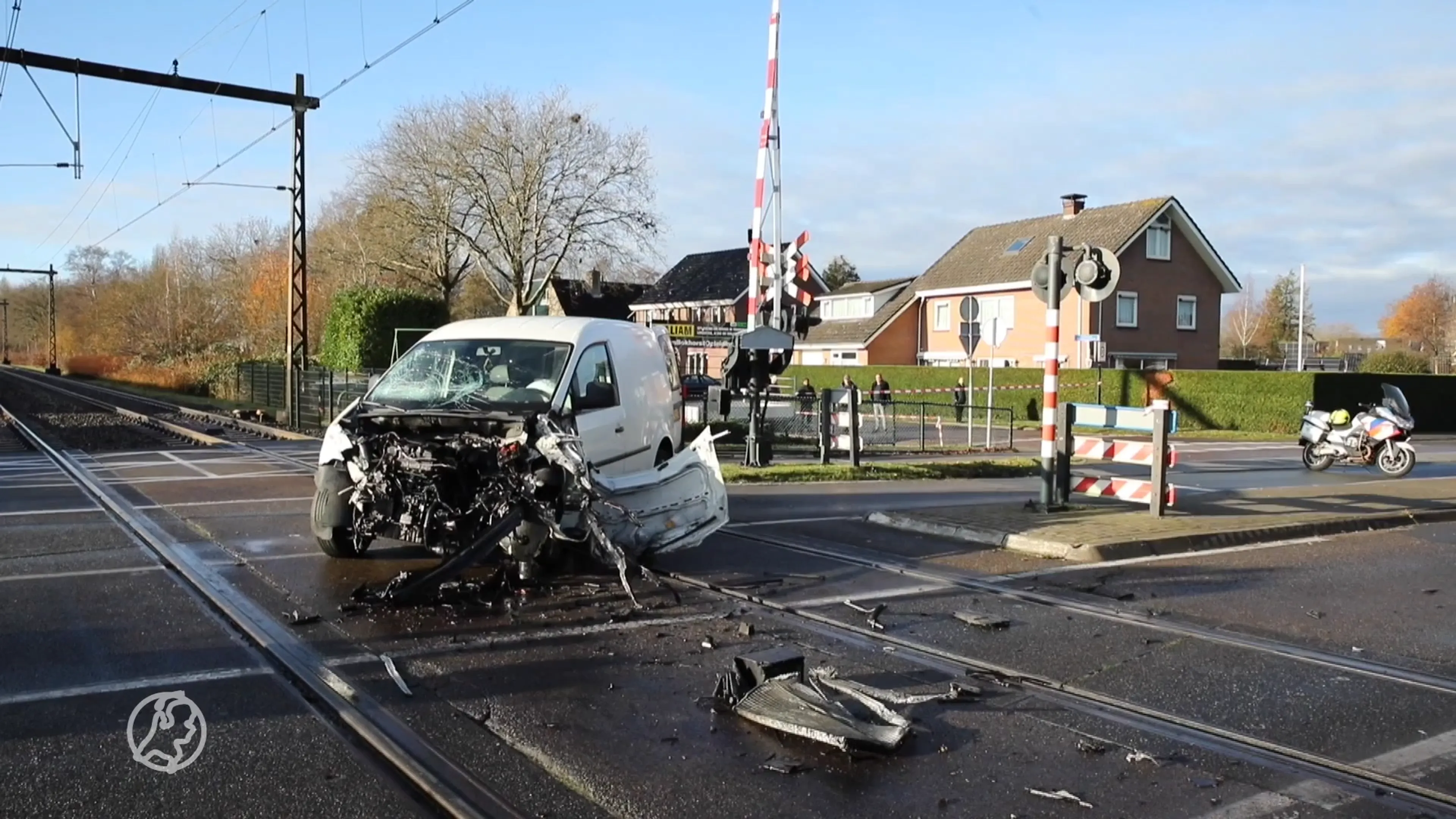 Bestelbus uiteengereten door botsing met trein, bestuurder stapt levend uit