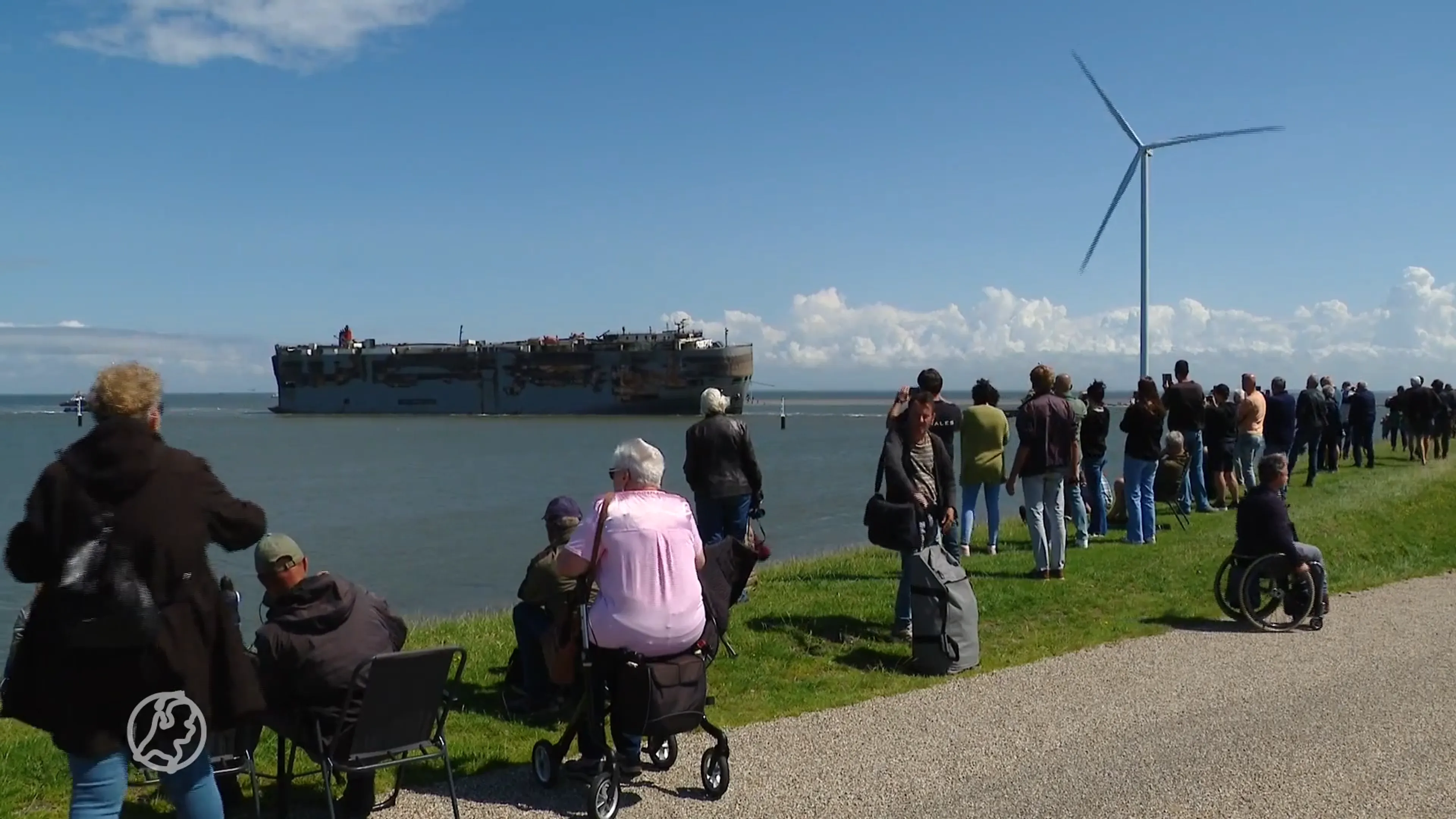 Tientallen mensen bekijken aankomst van door brand geraakte schip in Eemshaven