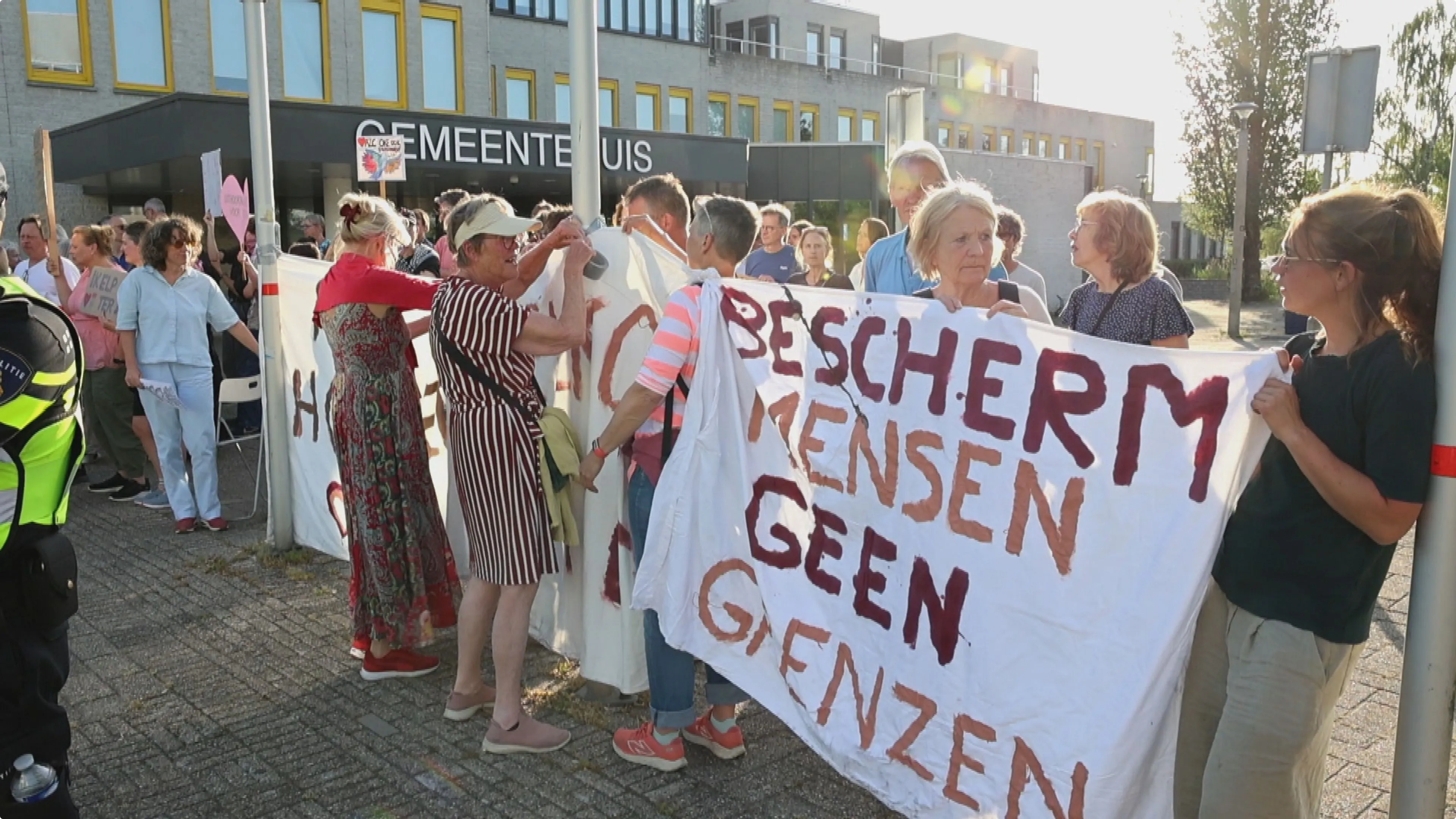 Voorstanders van het azc houden spandoeken omhoog. Beeld: HFV/MizzleMedia