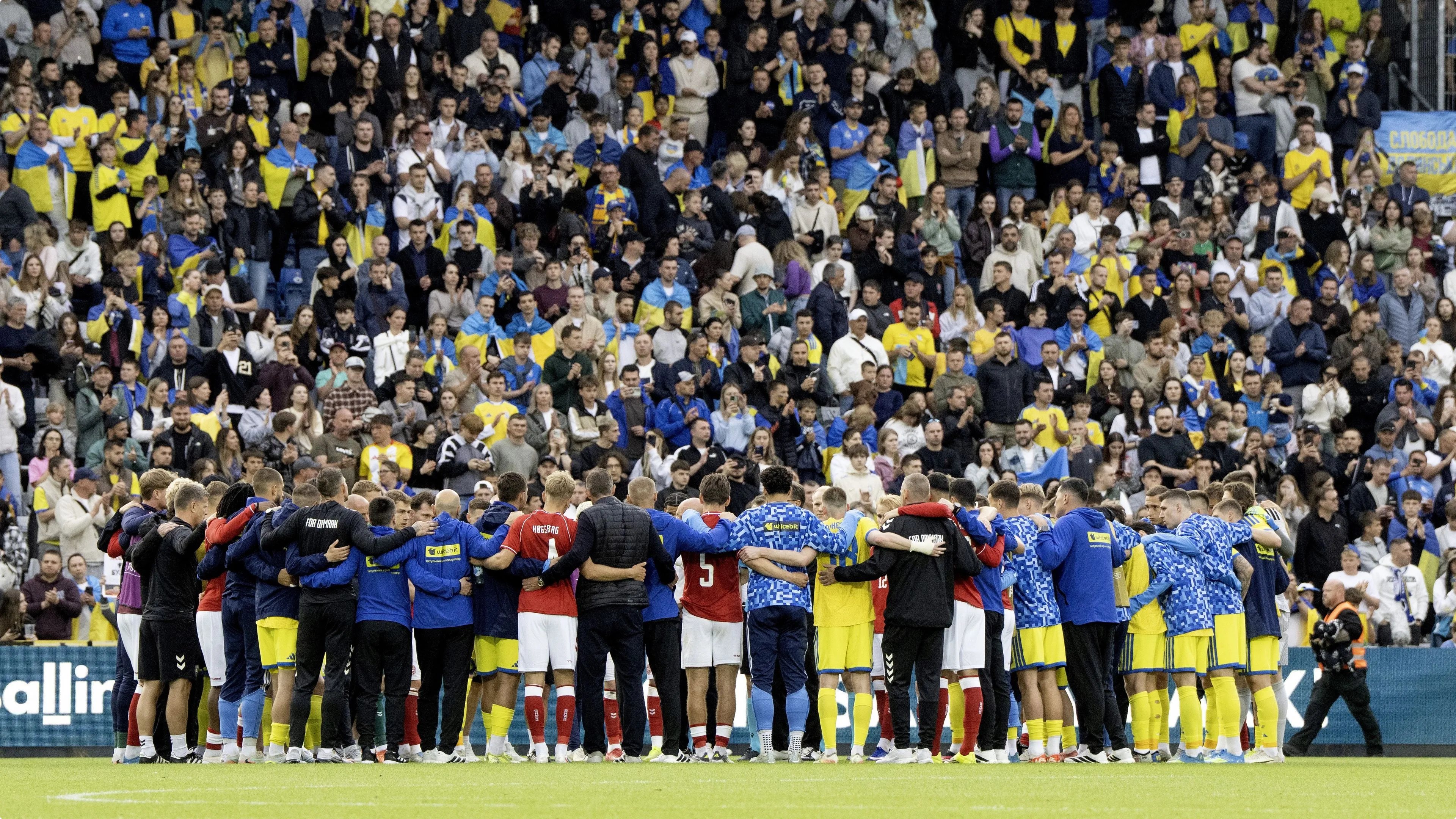 Spelers van Denemarken en Oekraïne verzamelden zich nadat Eriksen per ambulance was afgevoerd. Foto: ANP
