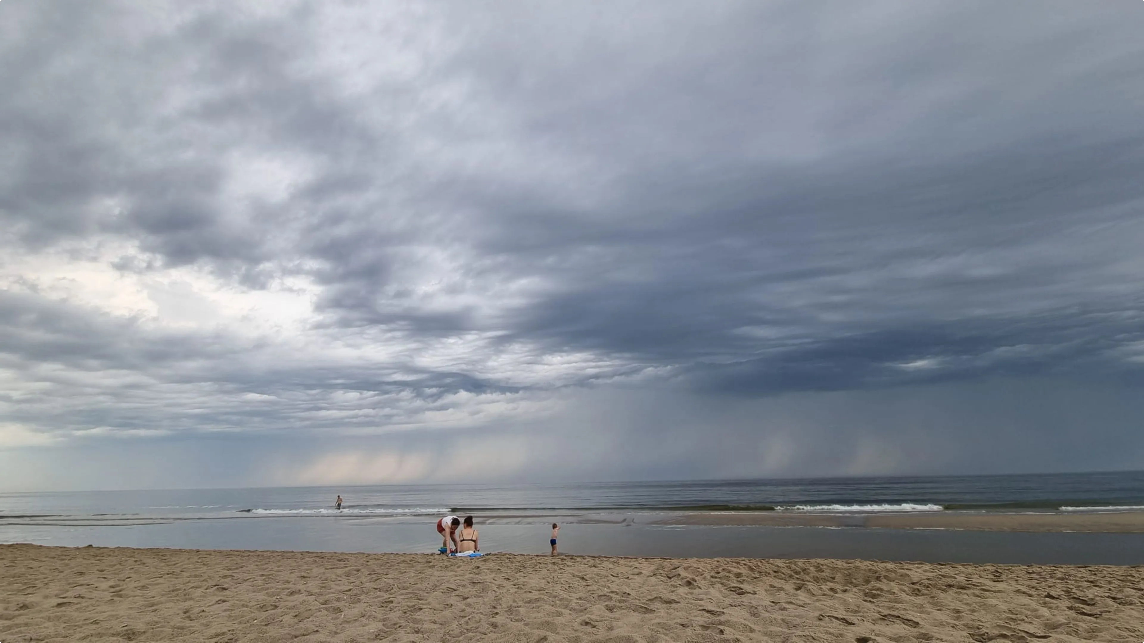Donkere wolken trekken via de kust het land in.